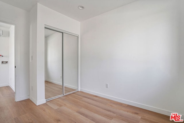 unfurnished bedroom with a closet and light hardwood / wood-style flooring