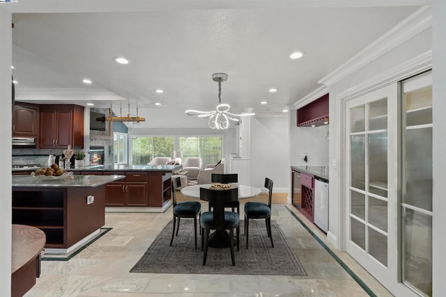 dining area featuring a notable chandelier, beverage cooler, and ornamental molding