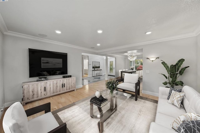 living room featuring a chandelier, crown molding, and light hardwood / wood-style floors