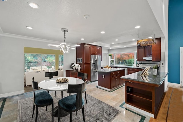 kitchen featuring tasteful backsplash, a center island, kitchen peninsula, hanging light fixtures, and stainless steel fridge