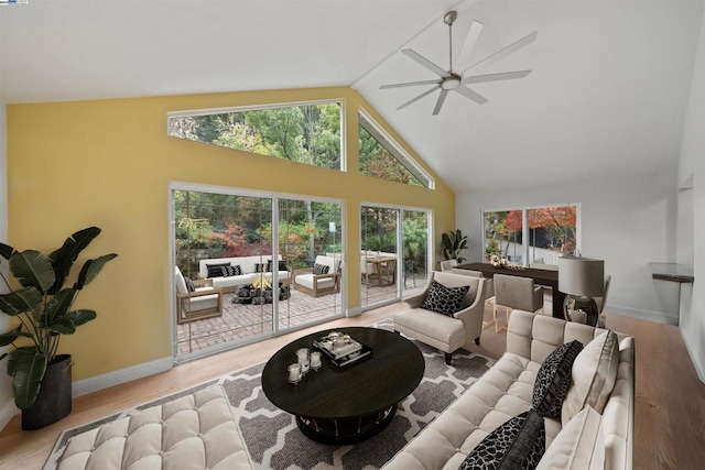 living room with ceiling fan, vaulted ceiling, and light hardwood / wood-style flooring