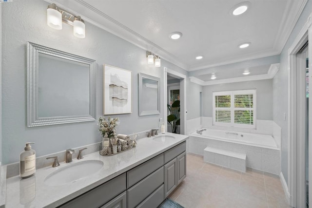 bathroom with ornamental molding, tile patterned floors, tiled tub, and vanity