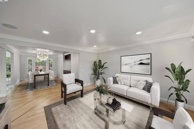 living room featuring light parquet flooring, ornamental molding, and a notable chandelier