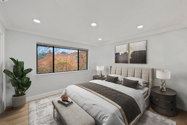 bedroom featuring crown molding and light hardwood / wood-style floors