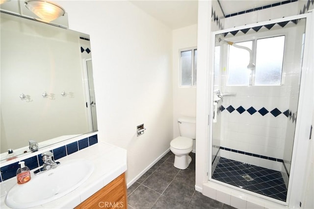 bathroom with tile patterned floors, vanity, a tile shower, and toilet