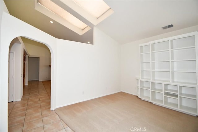 empty room featuring tile patterned flooring and lofted ceiling