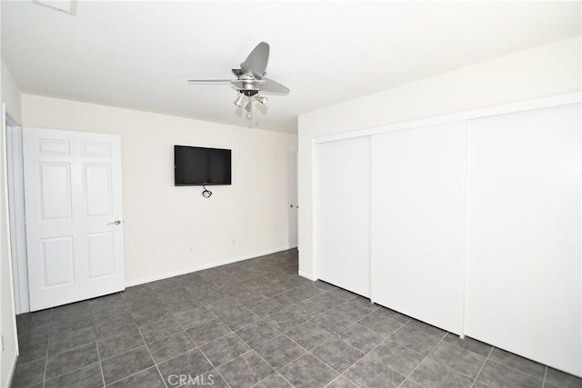 unfurnished bedroom with ceiling fan and a closet