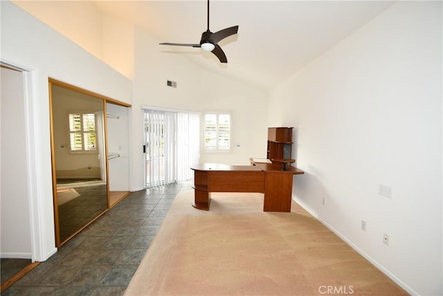 unfurnished office featuring dark colored carpet, high vaulted ceiling, and ceiling fan