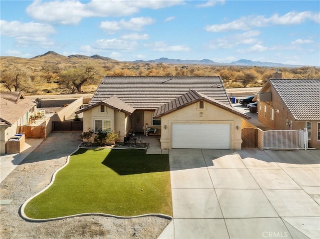 single story home featuring a mountain view, a garage, and a front lawn