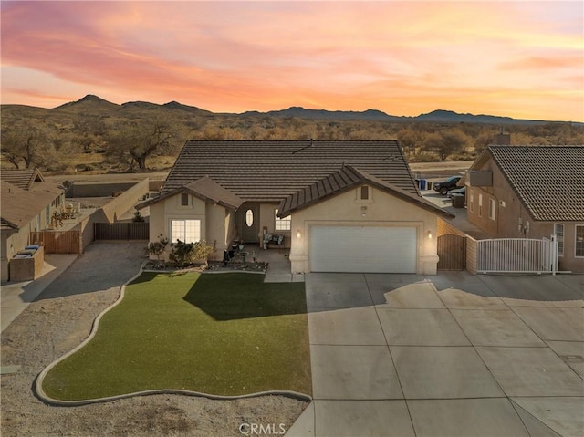 view of front of house featuring a lawn, a mountain view, and a garage