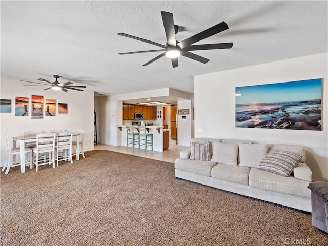 carpeted living room with a textured ceiling and ceiling fan