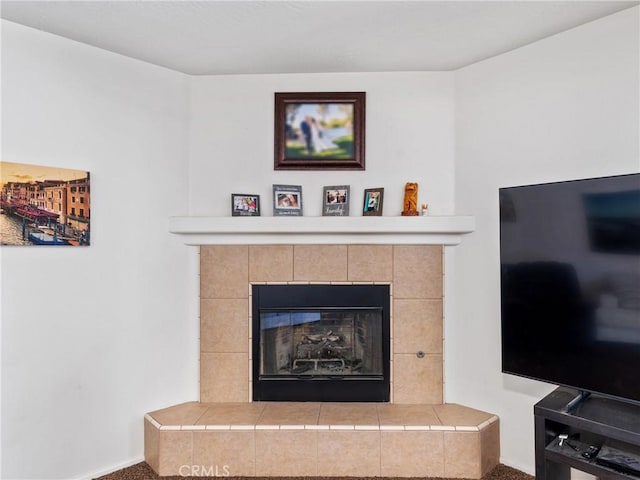 interior details featuring a tile fireplace and carpet