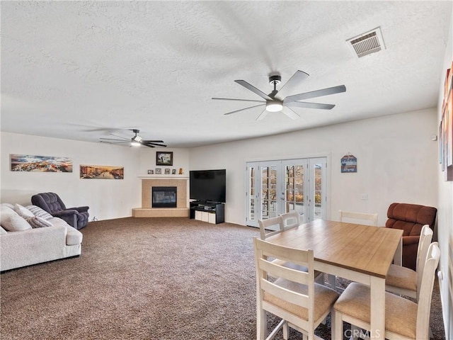 carpeted dining space featuring ceiling fan and a textured ceiling