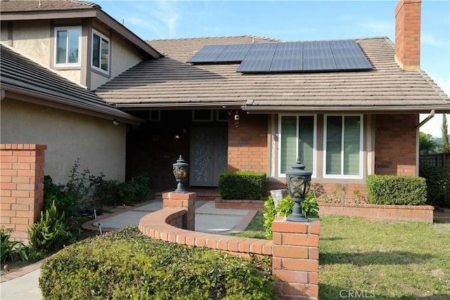 view of front of home featuring a front yard and solar panels