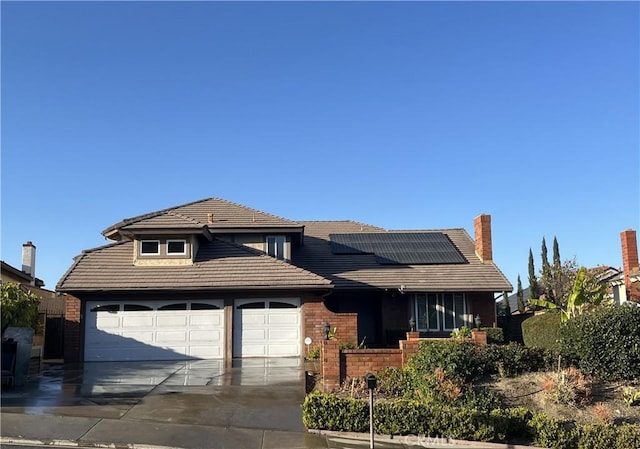 view of front of home featuring solar panels and a garage