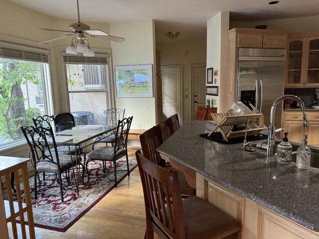 dining area featuring ceiling fan, a wealth of natural light, light hardwood / wood-style floors, and sink