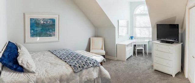 bedroom featuring lofted ceiling and light carpet