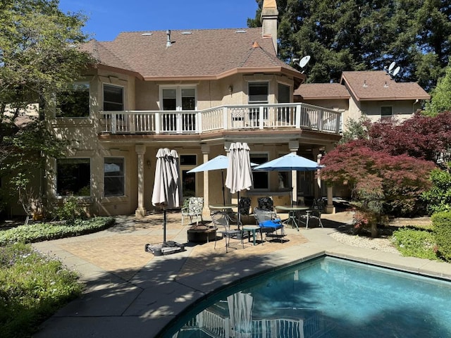 back of house with a patio area, an outdoor fire pit, and a balcony