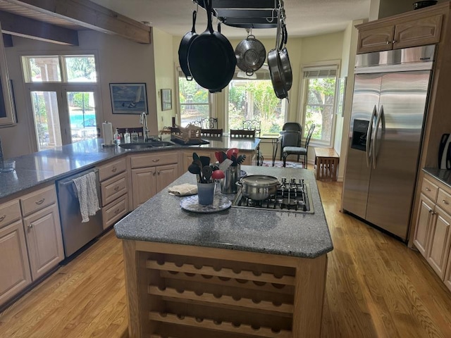 kitchen featuring sink, a center island, stainless steel appliances, and light hardwood / wood-style flooring