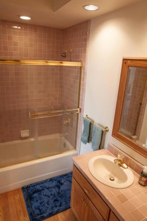 bathroom featuring tiled shower / bath, vanity, and hardwood / wood-style flooring