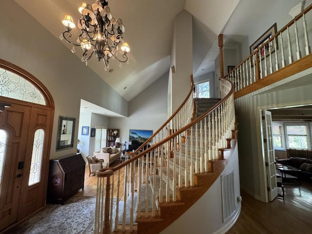 foyer featuring high vaulted ceiling, a notable chandelier, and dark wood-type flooring