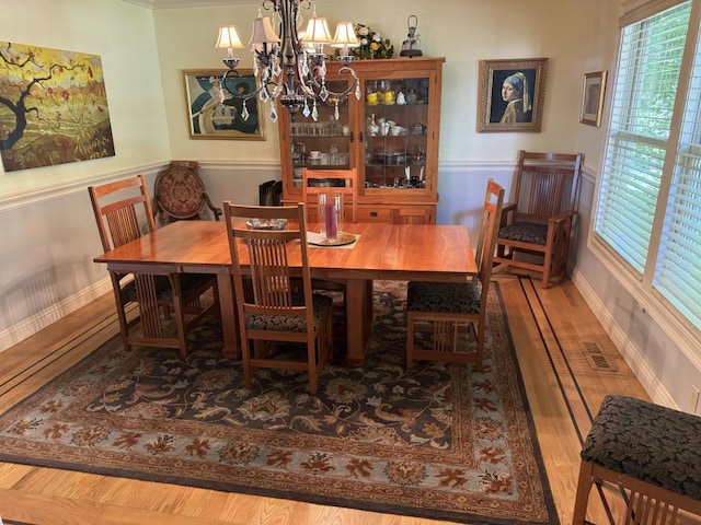 dining space featuring hardwood / wood-style flooring and an inviting chandelier