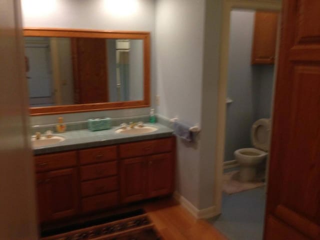 bathroom featuring toilet, vanity, and hardwood / wood-style floors