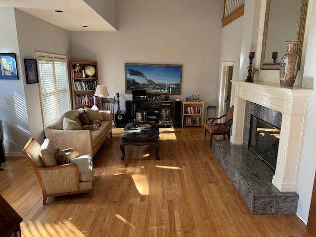 living room with light hardwood / wood-style floors and a premium fireplace