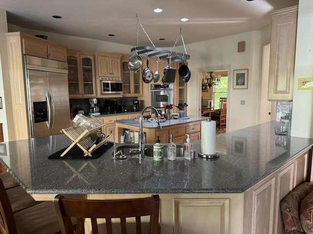 kitchen featuring an inviting chandelier, a large island, a breakfast bar area, stainless steel appliances, and light brown cabinets