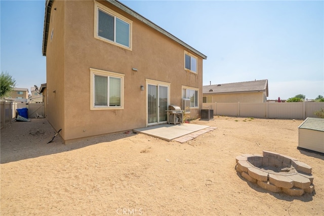 back of house featuring cooling unit, an outdoor fire pit, and a patio