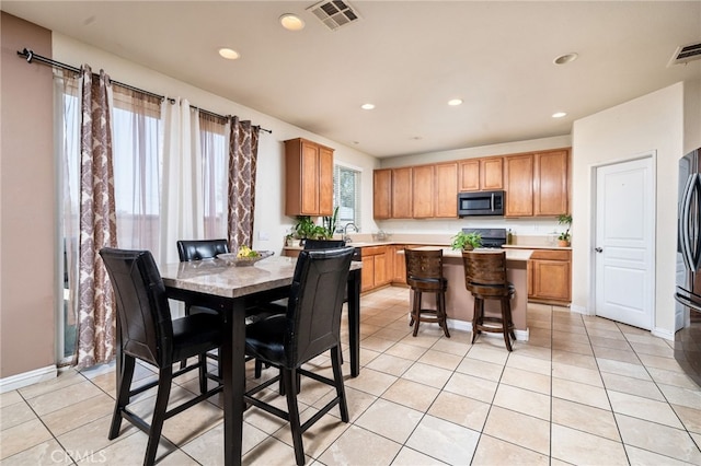 kitchen featuring plenty of natural light, a center island, light tile patterned floors, and appliances with stainless steel finishes