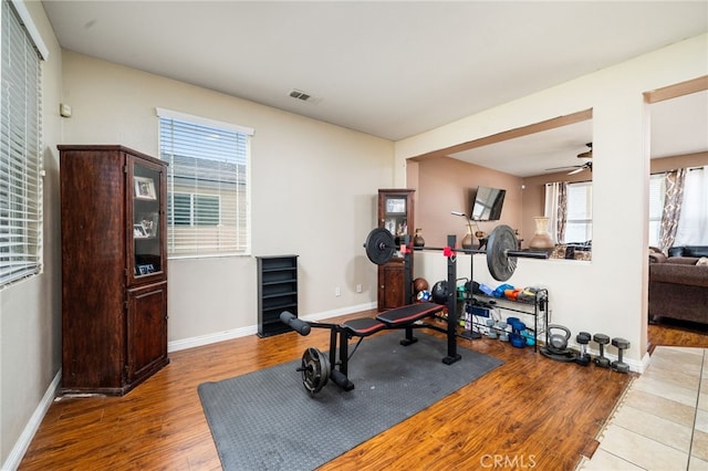 exercise room with ceiling fan and wood-type flooring