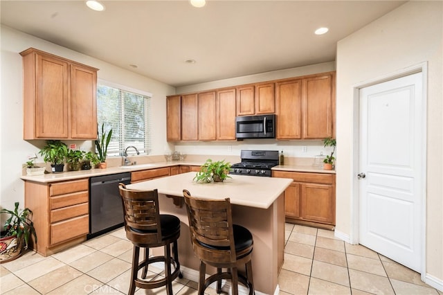 kitchen featuring light tile patterned flooring, a kitchen breakfast bar, sink, appliances with stainless steel finishes, and a kitchen island