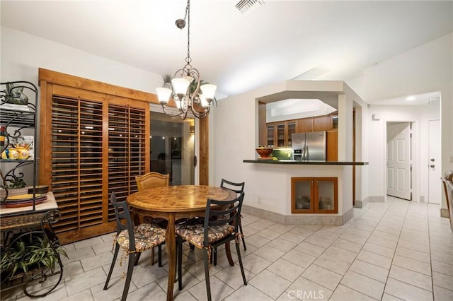 tiled dining space with an inviting chandelier