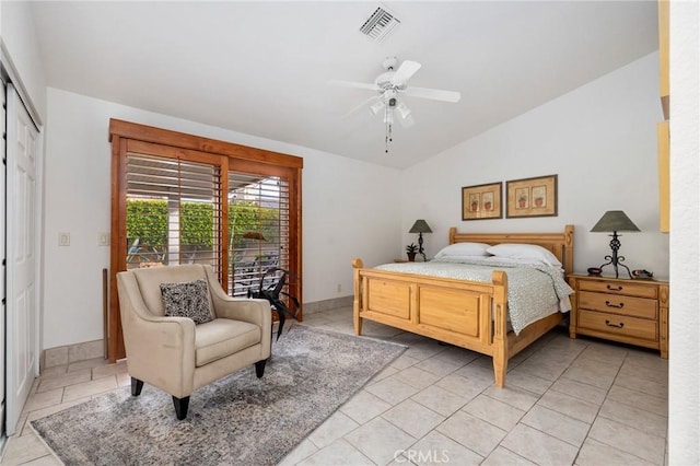 tiled bedroom with vaulted ceiling, ceiling fan, and a closet