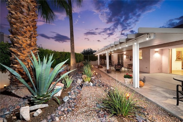 yard at dusk with a patio area