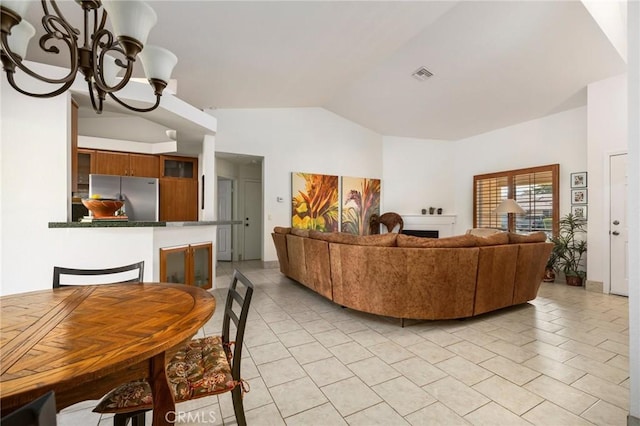 living room with lofted ceiling, light tile patterned floors, and an inviting chandelier