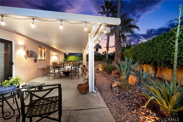 patio terrace at dusk featuring a fire pit