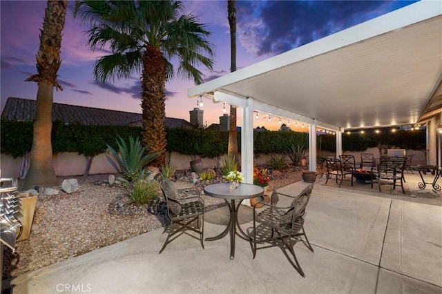 patio terrace at dusk featuring an outdoor fire pit