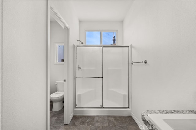 bathroom with a shower with door and toilet