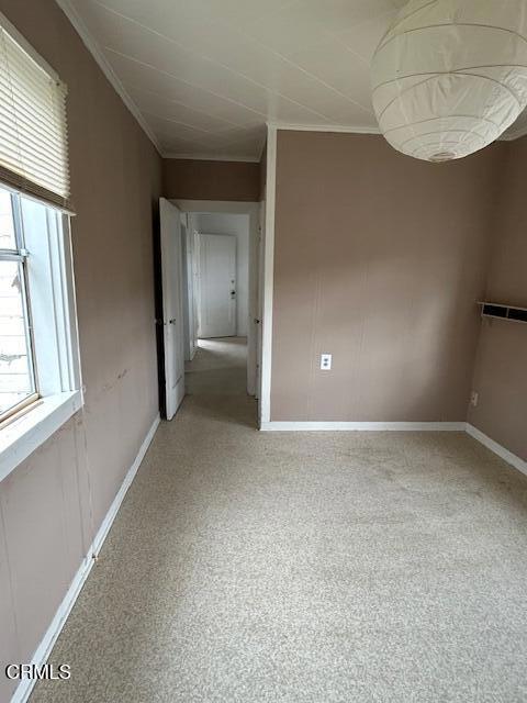 empty room featuring ornamental molding