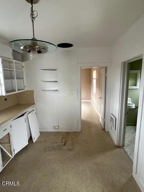 interior space with decorative light fixtures, white cabinets, and dishwasher