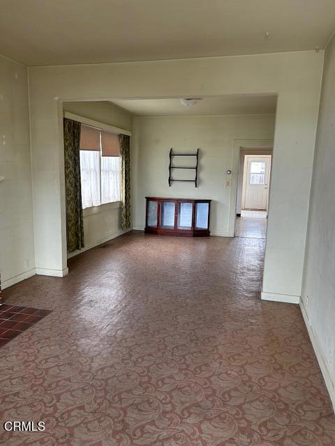 spare room with baseboards and a healthy amount of sunlight