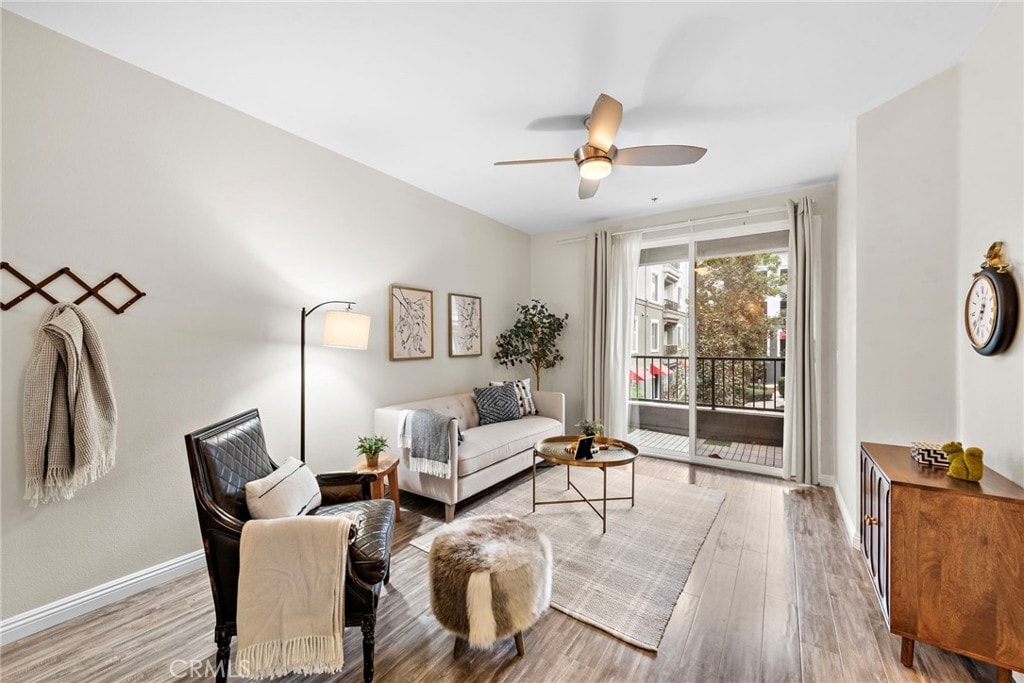 living room with light wood-type flooring and ceiling fan