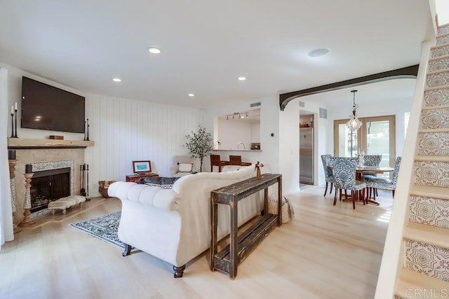 living room with light hardwood / wood-style flooring and a stone fireplace