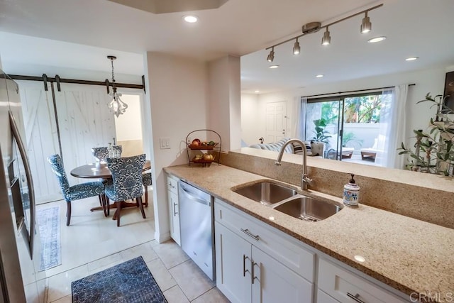 kitchen with light stone countertops, sink, a barn door, dishwasher, and white cabinetry