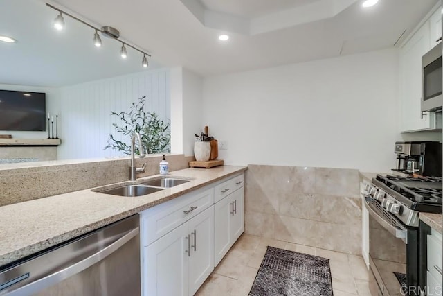 kitchen featuring white cabinets, light stone counters, sink, and appliances with stainless steel finishes