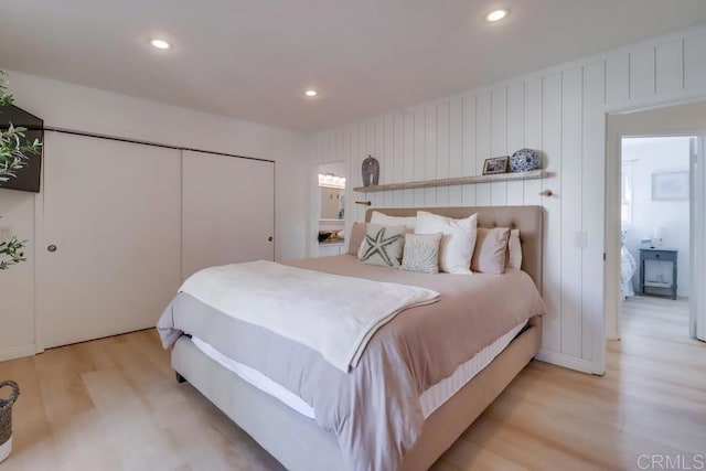 bedroom with light hardwood / wood-style floors and a closet