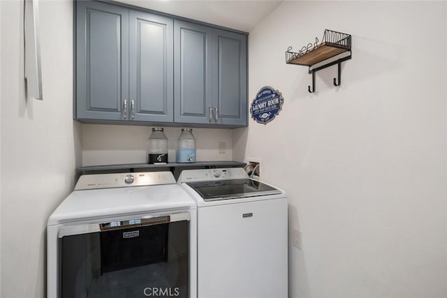 laundry room featuring cabinets and washer and clothes dryer