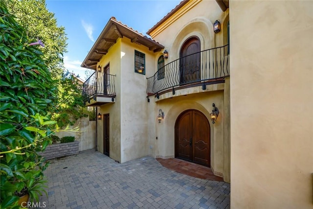 property entrance with a balcony and a patio area